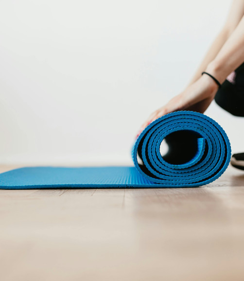 Photo of someone rolling out a Pilates mat